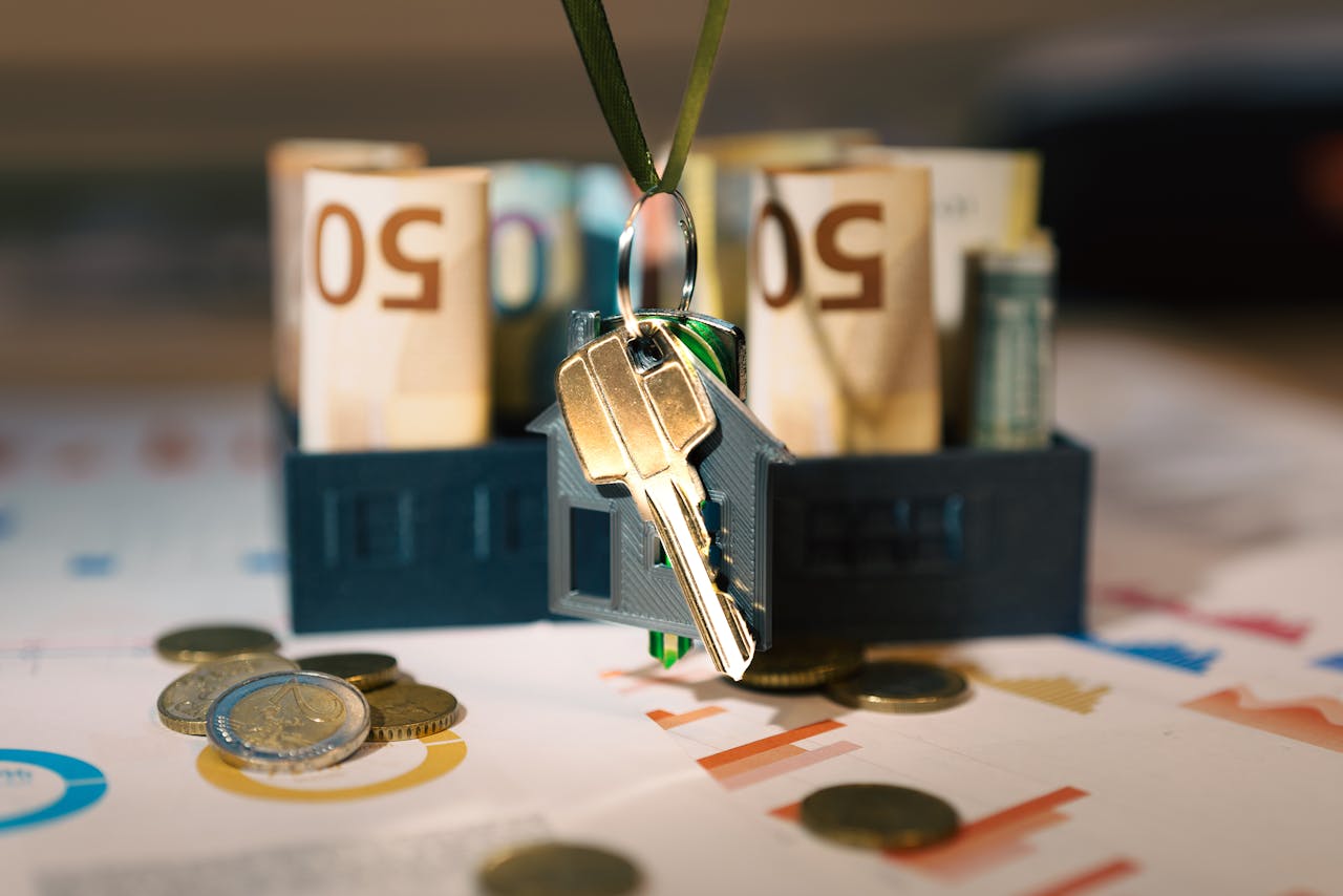 hero-img-02 Keys hanging with money and charts, symbolizing real estate investment and financial planning.