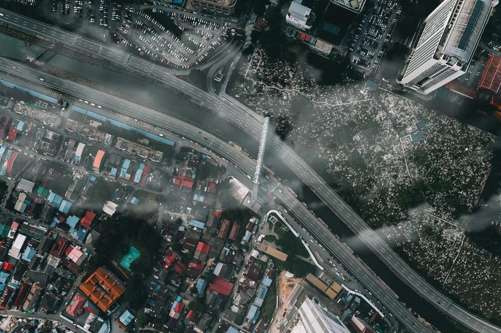 pexels-photo-5862796-5862796 Drone view of contemporary city under clouds with modern buildings and roads in soft daylight